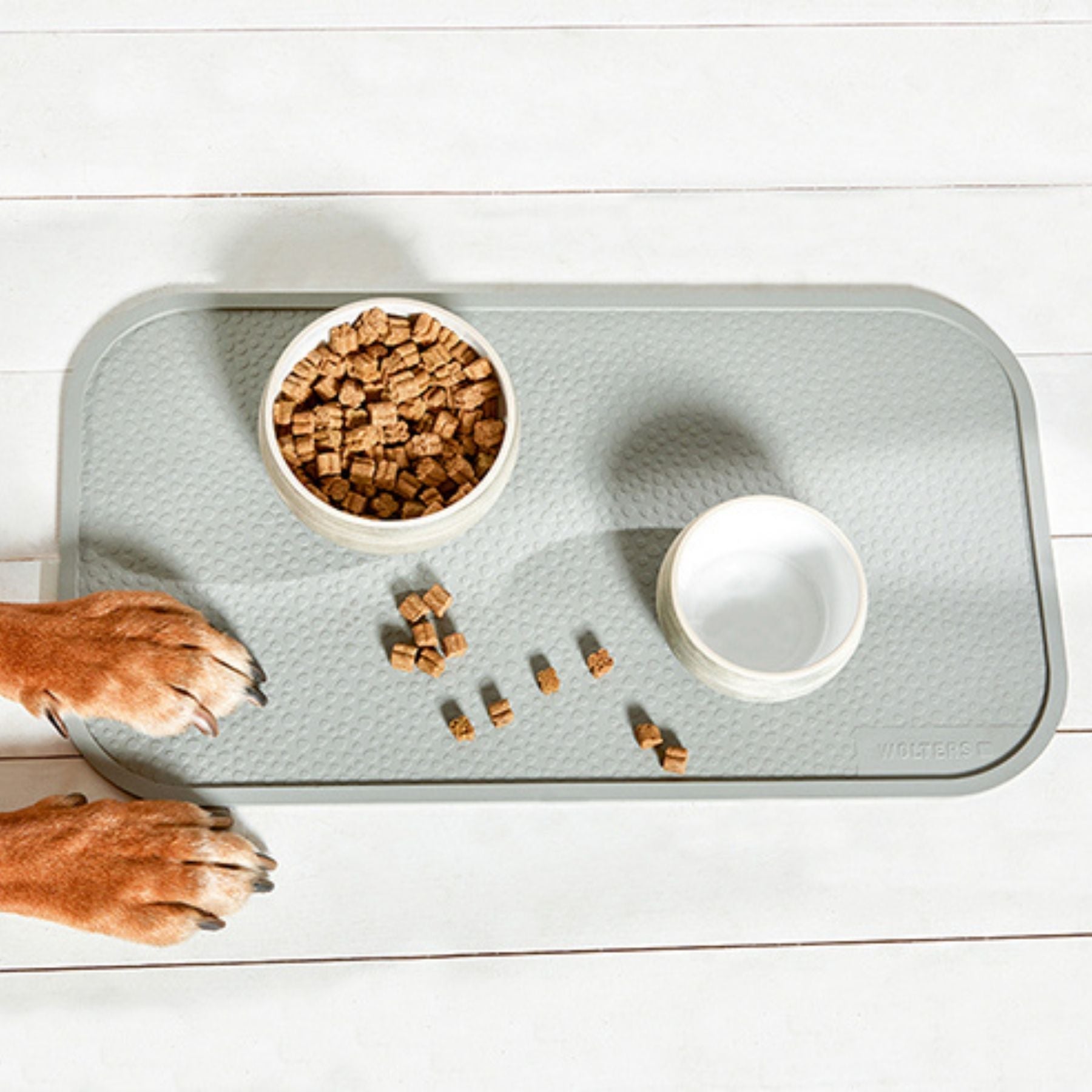 Dieses Foto zeigt eine Napfunterlage von Wolters. Sie ist aus Naturkautschuk und schützt deinen Boden vor Futter und Wasserspritzern. Die Hundenäpfe verrutschen durch die Matte nicht mehr. Bei PAWSOME ist die Matte in drei Farben erhältlich. Dies ist die Farbe Hellgrau.
